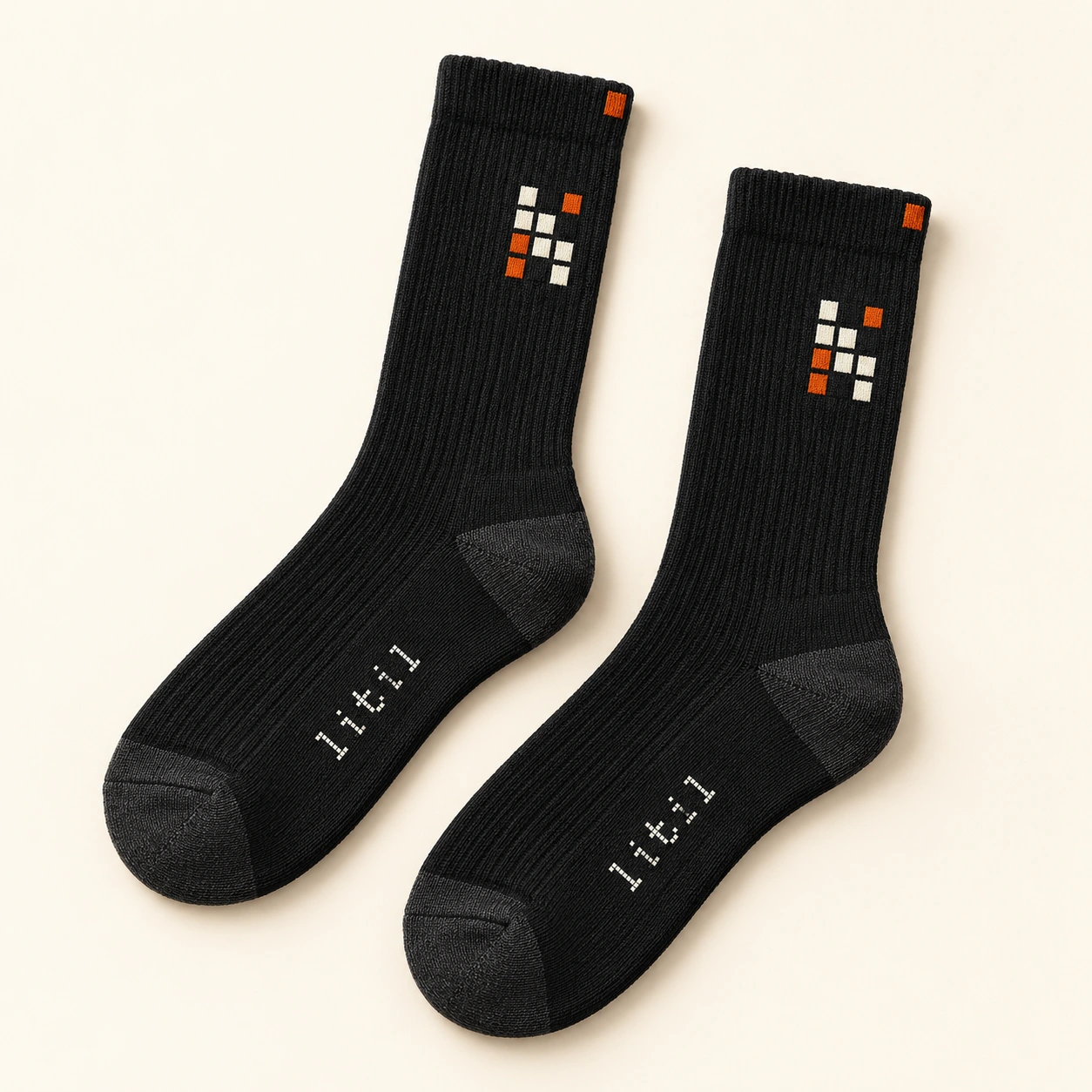 Charcoal LiTiL Signal crew socks with ivory and orange pixel motifs and small ivory logo on the foot